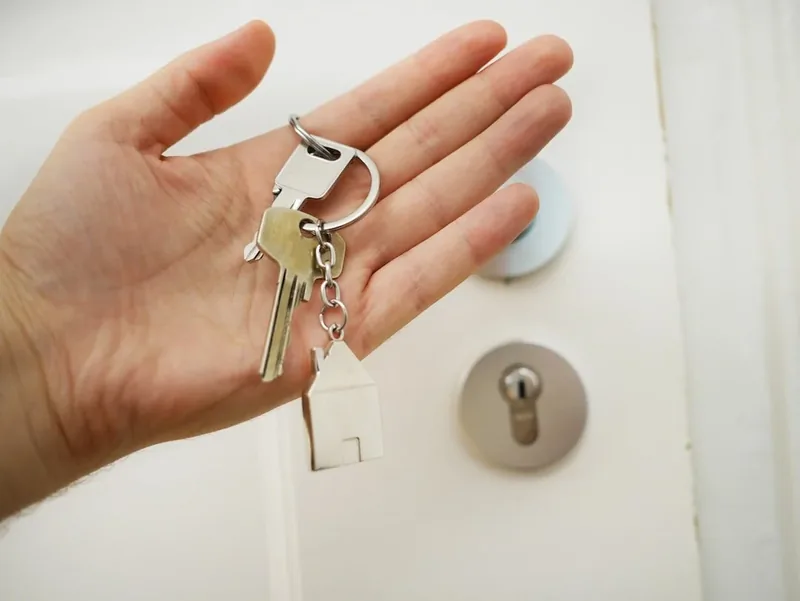 Open hand holding a set of house keys with a house-shaped keyring